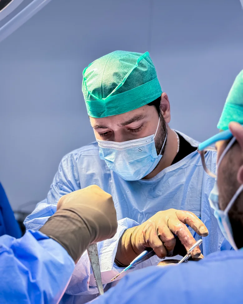 Equipo quirúrgico trabajando bajo las lámparas de quirófano